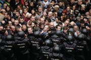 Spanische Polizeieinheiten riegeln in Barcelona den Zutritt zu einer Schule ab, wo sich ein Wahllokal befindet. In grösseren Orten – aber nicht überall – hat die Polizei die Wähler so von den Urnen ferngehalten. (Bild: Alberto Estevez/EPA)