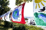 An vielen Orten in Zug wehen die bunt bemalten Fahnen als Mahnung für Toleranz. (Bild Werner Schelbert)