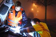 Eine Polizistin leuchtet das Arbeitsfeld eines TCS-Servicemanns aus. (Bild: Luzerner Polizei)