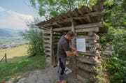 Fredy Achermann von der Stützpunkt Feuerwehr Nidwalden montiert das Feuerverbotsschreiben bei einem Grill- und Picknickplatz am Stanserhorn in Stans. (Bild: Keystone / Urs Flüeler)