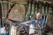 Anton Beeler repariert Sensen in seiner Werkstatt auf dem Hof seines Sohnes. (Bild: Nadia Schärli (Einsiedeln, 17. August 2017))