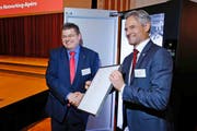 Der Zuger Volkswirtschaftsdirektor Matthias Michel (rechts) übergibt die Siegerurkunde Philipp Hofmann von der V-Zug AG. (Bild: Stefan Kaiser / Neue ZZ)