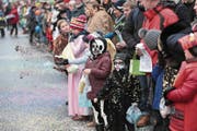 Die Traditionsfiguren der Baarer Fasnacht, die Räbegäuggel (oben links), sorgten für Stimmung am Umzug in Baar. Ebenso wie dieser Vertreter der Fröschenzunft Ebel (oben rechts). Im Umzug dabei alt Räbevater Beat Villiger (Mitte rechts), der Besuch aus der March, die Märchler Rölli (unten rechts) und die Zuschauer (unten links). (Bilder: Roger Zbinden (Baar, 11. Februar 2018))