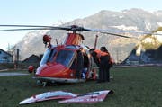 Zwei Polizeibeamte inspizieren den beschädigten Rega-Helikopter. Für die Rettung der Verunfallten wurden die Türen des Helikopters entfernt. (Bild: Anian Heierli / Neue UZ)