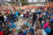 Stadträtin Manuela Jost und Volksschulrektor Rolf von Rohr (Mitte, leicht verdeckt) mit Felsberg-Schülern beim Vergraben der Schatztruhe mit guten Wünschen für die Schulhaussanierung. (Bild: Dominik Wunderli / Neue LZ)