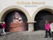 Werbeplakat von einer Dame mit Bierschaumschnauz vor dem Restaurant Rathaus Brauerei (Bild: Ramona Geiger)