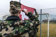 Eine Frau in der Schweizer Armee: Morgens beim Antrittsverlesen wird die Schweizer Flagge gehisst, in Achtungstellug gestanden und die Fahne gegrüsst. Aufgenommen wurde das Bild während der Ausbildung zu Swisscoy Soldaten, in der Nähe der Kaserne in Stans im Jahr 2014. (Bild: Keystone)