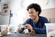 «Man kann aus Papier fast alles machen»: Sipho Mabona mit selbst entworfenen Origami-Tieren - Stier, Trilobit (ein Gliederfüssler) und Tintenfisch. (Bild: Manuela Jans / Neue LZ)