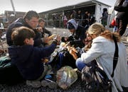 Eine Flüchtlingsfamilie bei der Rast in der Nähe von Tabanovce, Mazedonien. Vom dortigen Transitcenter geht ihre Reise weiter über die serbische Grenze nach Presevo. (Bild: Keystone/Boris Grdanoski)