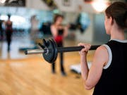 Eine Frau trainiert in einem Fitnessstudio (Archiv) (Bild: KEYSTONE)