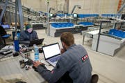 Mitarbeiter programmieren den Automatisierungsprozess. (Bild: Dominik Wunderli)