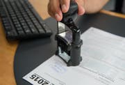 Ein Mitarbeiter des Steueramt der Stadt Luzern macht einen Stempel auf eine Steuererklärung (Symbolbild). (Bild: Dominik Wunderli)