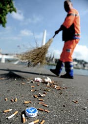 Mühsame Arbeit: Ein Mitarbeiter des Strasseninspektorats beim Zusammenkehren von Stummeln. Abhilfe schaffen sollen verteilte Aschenbecher für die Tasche. (Bild: Nadia Schärli / Neue LZ)