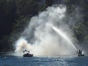 Die Feuerwehr bekämpft den Brand vom See aus. (Bild Jürg Weber)