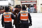 Zwei Polizisten unterhalten sich in Luzern mit einem Fasnächtler. (Bild: Jakob Ineichen (Luzern, 12. Februar 2018))