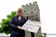Erna Blättler-Galliker, Geschäftsführerin von Nidwalden Tourismus, zeigt den neuen Prospekt vor dem Schnitzturm in Stansstad - ebenfalls ein Aussichtspunkt. (Bild: Corinne Glanzmann / Neue NZ)