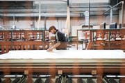 Ein Angestellter von Argolite arbeitet an einer neu installierten Anlage für Laminatplatten. Bild: Manuela Jans-Koch (Willisau, 11. November 2016)