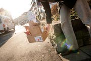Ein Mann stellt in Luzern Karton auf die Strasse. (Bild: Roger Gruetter / Neue LZ)