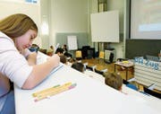 Kinder sitzen im Lesesaal der Pädagogischen Hochschule Zug und hören einen Vortag über Therapiehunde.