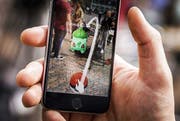 Das Spiel Pokémon Go findet per Einblendung von Monstern in das laufende Kamerabild statt. (Bild: EPA / Remko de Waal)