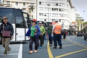 Eine Reisegruppe am Löwenplatz auf dem Weg zu ihrem Car. Überwacht wird das Ganze von einem Verkehrslotsen. (Bild Corinne Glanzmann)