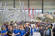 Blick in die neue Ruag-Raumfahrthalle 9 in Emmen gestern bei der Schlüsselübergabe, in der Mitte die Ruag-Aviation-Werksmusik. Hinten rechts «Vega»-Raketen-Formen aus Stahl, die als «Backformen» für die Fertigung der Raketenverkleidungen dienen. (Bild Pius Amrein)