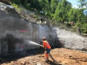 Bei Stütze 1 muss der Hang bergwärts mit Felsankern gesichert und mit Spritzbeton verfestigt werden. Das benötigte Wasser wurde zum Teil per Helikopter hochgeflogen. (Bild: PD/Rita Baggenstos, LKRS AG)