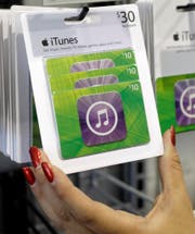 Customer picks up an Apple iTunes gift card on display at a Best Buy in Mountain View, Calif., Tuesday, July 17, 2012. (AP Photo/Paul Sakuma) (Bild: Paul Sakuma (AP))