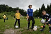 Hier wird bald auf Kunstrasen gespielt: Ruth Indergand vom Vorstand des FC Adligenswil mit Spielern der F-Junioren auf dem alten Fussballplatz. (Bild: Nadia Schärli)