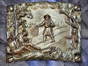 Das Gleichnis vom Weizen wird auf der Bronzetafel dargestellt: Der Sämann streut den Weizen, der Teufel (rehts, im Gehölz) säät derweil Unkraut. (Bild: Andreas Fässler / Neue ZZ)