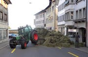 Ein Taktor in Schwierigkeiten: Sein Anhänger ist gekippt, Heuballen türmen sich auf der Strasse. (Bild: Kantonspolizei Schwyz (Arth, 7. April 2017))