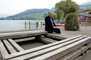 Jo Achermann sitzt im Sarner Seefeld auf seiner Installation aus Eichenbalken. (Bild Primus Camenzind)