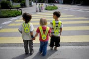 Schüler warten an einem Fussgängerstreifen, bis sie die Strasse gefahrlos überqueren können. (Symbolbild Pius Amrein)