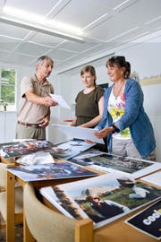 Klaus Bilang, OK-Mitglied, Szenografin Nina Bilang und Helferin Claudia Henggeler (von links) bereiten gemeinsam die Ausstellung im Haus am See in Unterägeri vor. (Bild Maria Schmid)