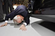 VW-Chef Martin Winterkorn muss derzeit unten durch. Das Bild zeigt ihn mit prüfendem Blick unter ein Fahrzug während des Genfer Autosalons. (Bild: EPA/Marijan Murat)