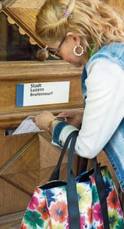 Eine Luzernerin wirft ihr Stimmcouvert in den Briefkasten beim Stadthaus in Luzern. (Bild: Eveline Beerkircher (17. Mai 2017))