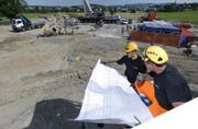 Zwei Bauarbeiter auf der Baustelle am Knoten Rigistrasse in Inwil studieren die nächsten Bauaktivitäten für die Tangente Zug/Baar. (Bild: Stefan Kaiser/ZZ)