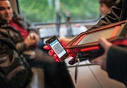 Eine Zugbegleiterin scannt ein elektronisches Ticket. (Bild: Keystone/Christian Beutler)
