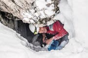 Exkursionsleiter Pius Schnider schaufelt den Zugang zu einer Höhle unterhalb der Schrattenfluh frei. (Bild: Nadia Schärli (4. Februar 2018))