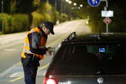 Ein Zuger Polizist kontrolliert den Ausweis eines Automobilisten. (Bild: Stefan Kaiser (Neue ZZ))