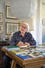 Seine Schriftzeugnisse füllen einen ganzen Tisch: Eduard Kloter (90) beim Signieren eines Buchs in seinem Zuhause in Meggen. (Bild Nadia Schärli)