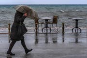Eine Frau schützt sich mit ihrem Schirm vor Regen und Wind. (Symbolbild Georgi Licovski (Ohrid, 30. November 2017))