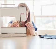 Eine Schülerin lernt den Umgang mit der Nähmaschine. (Symbolbild: Keystone/Christian Beutler)