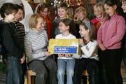 Schüler in Baar haben für die Weihnachtsaktion 2008 mit dem Verkauf von Engel 10'500 Franken gesammelt. Sie übergeben stolz den Geldcheck. Bild Philipp Schmidli/Neue LZ