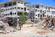 Syrische Soldaten patrouillieren in einem Quartier von Aleppo. Der Stadtteil wurde von den Rebellen vor kurzem zurückerobert. (Bild: EPA)