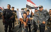 Irakische Sicherheitskräfte und Zivilisten feiern die gestrige Befreiung von Mossul. (Bild: Ahmad Al-Rubaye/AFP (Mossul, 9. Juli 2017))