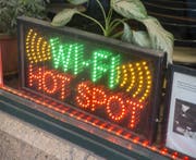 Eine Leuchtreklame in einem Restaurant lockt Gäste mit einem WLAN-Hotspot an. (Bild: Imago)