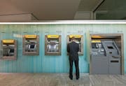 Ein Mann bezieht am Postomaten der Poststelle am Bärenplatz in Bern Geld. (Bild: Gaetan Bally/Keystone (16. Juli 2012))