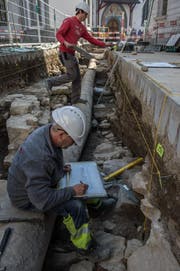 Die Archäologen Luca Winiger (hinten) und Andreas Christen graben die überreste der Mauer der alten Spitalkirche aus. Sie wurden bei der Strassensanierung in der Kleinstadt am Franziskanerplatz entdeckt. (Bild: Nadia Schärli (Luzern, 15. März 2017))