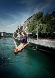 Die Hitze lockt Schwimmer in die Flüsse und verleitet viele dazu, von Brücken ins Wasser zu springen - so wie Dominik Furrer bei der Luzerner Spreuerbrücke. (Bild: Pius Amrein / Neue LZ)